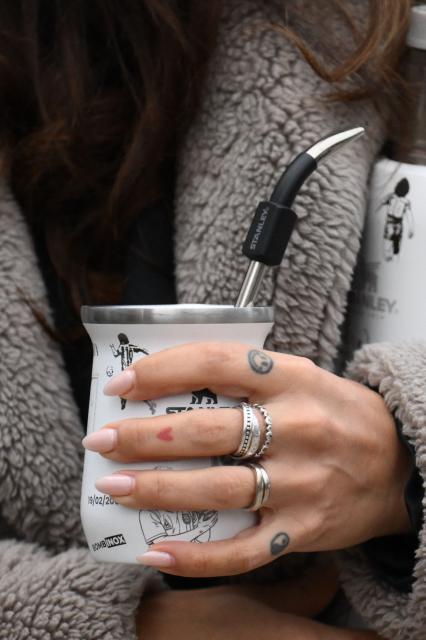 Gianinna Maradona, daughter of Argentine football legend Diego Maradona, holds a mate cup with images depicting her father as she arrives at the court for a trial hearing on her father's death in San Isidro, Buenos Aires province, Argentina on June 9, 2026. (Photo by Luis ROBAYO / AFP)