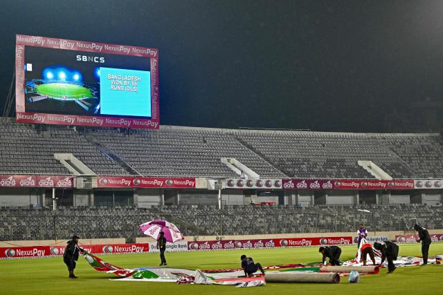 Groundsmen work after play was abandoned due to rain leading to Bangladesh’s victory against Australia by the DLS (Duckworth–Lewis–Stern) method during their first one-day international (ODI) cricket match at the Sher-e-Bangla National Cricket Stadium in Dhaka on June 9, 2026. (Photo by Munir UZ ZAMAN / AFP)