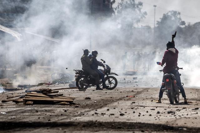 TOPSHOT - Plainclothes Kenyan police officers riding motorcycles brandish pistols amid teargas during clashes with protesters at a demonstration against a controversial US-built Ebola quarantine centre slated to begin operations at Laikipia Air Base in Nanyuki on June 9, 2026. Several Kenyans were arrested on June 9, 2026 in the latest protests against an Ebola quarantine centre being built for US citizens in a tourist town.
The centre at Laikipia Air Base in the town of Nanyuki, under the shadow of Mount Kenya, is set to quarantine Americans arriving from the Democratic Republic of Congo (DRC), which is battling a major Ebola outbreak. (Photo by Luis TATO / AFP)