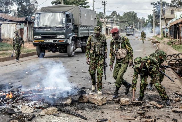 Kenyan police officers remove burning barricades from a road during clashes with protesters at a demonstration against a controversial US-built Ebola quarantine centre slated to begin operations at Laikipia Air Base in Nanyuki on June 9, 2026. Several Kenyans were arrested on June 9, 2026 in the latest protests against an Ebola quarantine centre being built for US citizens in a tourist town.
The centre at Laikipia Air Base in the town of Nanyuki, under the shadow of Mount Kenya, is set to quarantine Americans arriving from the Democratic Republic of Congo (DRC), which is battling a major Ebola outbreak. (Photo by Luis TATO / AFP)