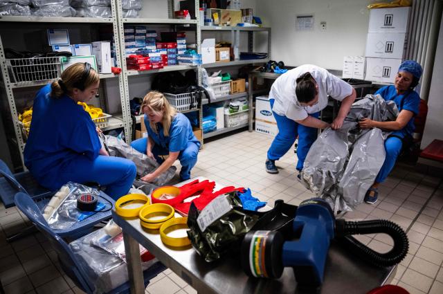 Nurses help their colleagues get into their PPE (Personal Protection Equipment) as they simulate the reception of a patient with a highly infectious disease such as Ebola, at the special isolation ward of the Department of Infectious Diseases at the Charite Virchow hospital in Berlin on June 9, 2026. The German hospital discharged a US man who caught Ebola in the Democratic Republic of Congo, after 17 days of antiviral treatment and medical care cured him of the often deadly infection. The Charite public hospital in Berlin said the man -- who had been working as a surgeon for a Christian missionary group in the DRC -- and his five family members who had all been in quarantine were in "good health" and permitted to leave. (Photo by John MACDOUGALL / AFP)