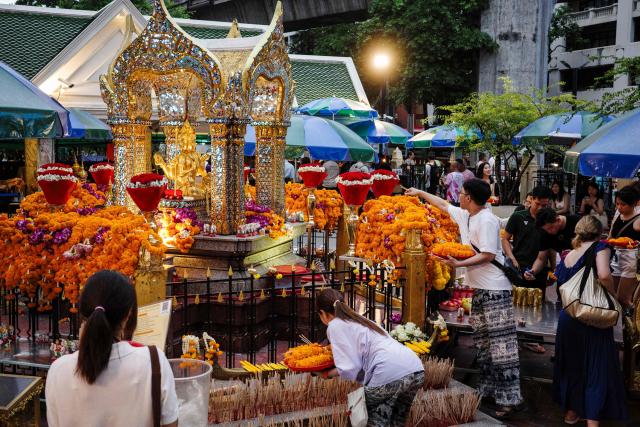 Visitors pray and leave offerings at the Buddhist Erawan Shrine in Bangkok on June 9, 2026. (Photo by ANTHONY WALLACE / AFP)