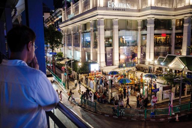 A man prays as he faces the Buddhist Erawan Shrine (bottom R) on an elevated walkway in Bangkok on June 9, 2026. (Photo by ANTHONY WALLACE / AFP)