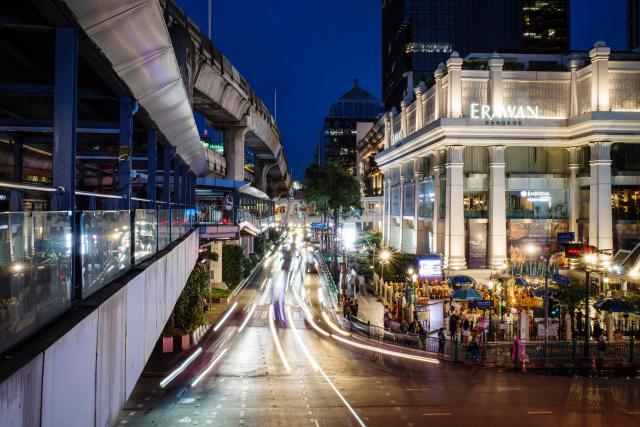 This long exposure photo shows cars driving past the Buddhist Erawan Shrine (R) in Bangkok on June 9, 2026. (Photo by ANTHONY WALLACE / AFP)