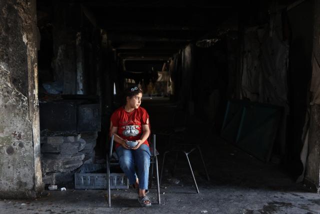 A Palestinian girl sits inside the complex of a school sheltering displaced people at the Jabalia refugee camp in the northern Gaza Strip, on June 9, 2026. (Photo by Omar AL-QATTAA / AFP)
