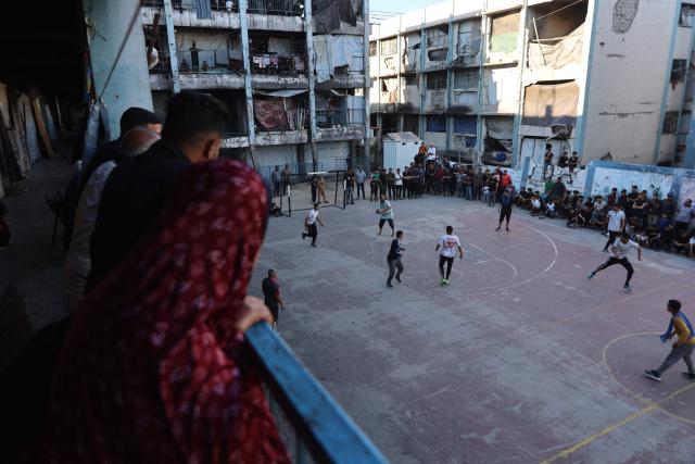 People watch Palestinians playing football inside a school sheltering displaced people at the Jabalia refugee camp in the northern Gaza Strip, on June 9, 2026. (Photo by Omar AL-QATTAA / AFP)