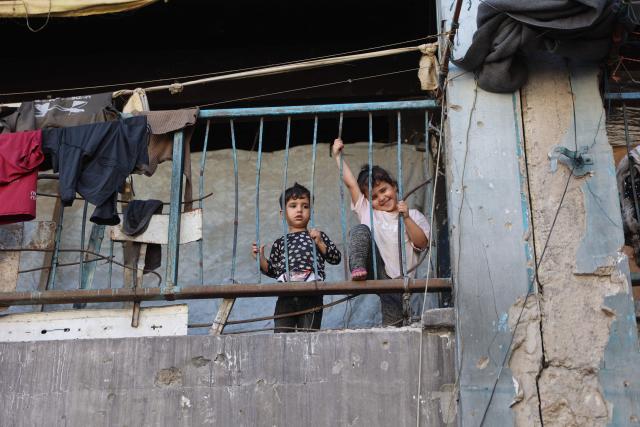 Children watch Palestinians playing football inside a school sheltering displaced people at the Jabalia refugee camp in the northern Gaza Strip, on June 9, 2026. (Photo by Omar AL-QATTAA / AFP)