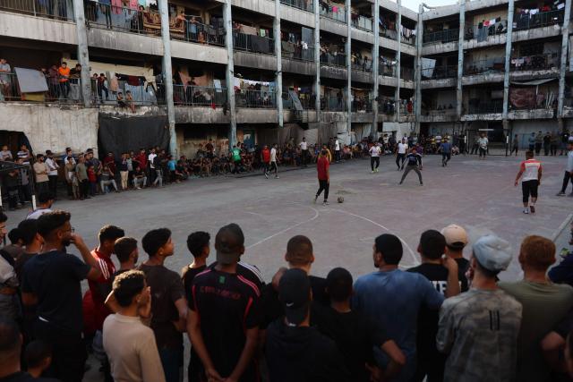 People watch Palestinians playing football inside a school sheltering displaced people at the Jabalia refugee camp in the northern Gaza Strip, on June 9, 2026. (Photo by Omar AL-QATTAA / AFP)