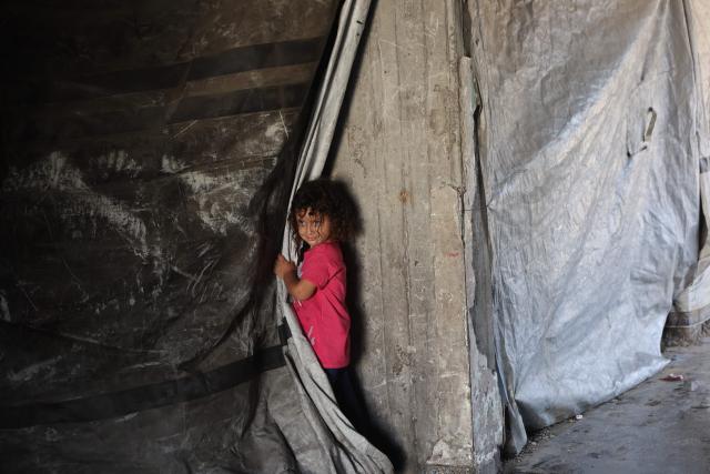 A Palestinian child plays inside the complex of a school sheltering displaced people at the Jabalia refugee camp in the northern Gaza Strip, on June 9, 2026. (Photo by Omar AL-QATTAA / AFP)