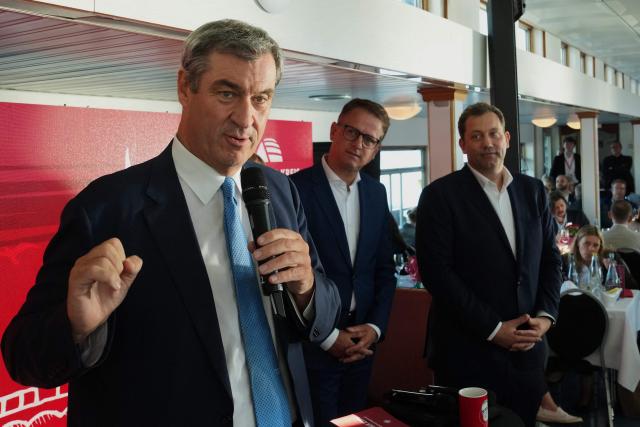 (L-R) Bavaria's State Premier and leader of the conservative Christian Social Union (CSU) Markus Soeder speaks next to Secretary General of Germany's Christian Democratic Union (CDU) Carsten Linnemann and German Vice Chancellor and Finance Minister Lars Klingbeil at the Social Democratic Party's (SPD) 'Seeheimer Kreises Spargelfahrt' (Asparagus tour of the Seeheimer Group) in Berlin, on June 9, 2026. Bavarian State Governor Markus Soeder, left, speaks besides German Vice Chancellor and Finance Minister Lars Klingbeil, right, and CDU Secretary General Carsten Linnemann, background left (Photo by Markus Schreiber / POOL / AFP)