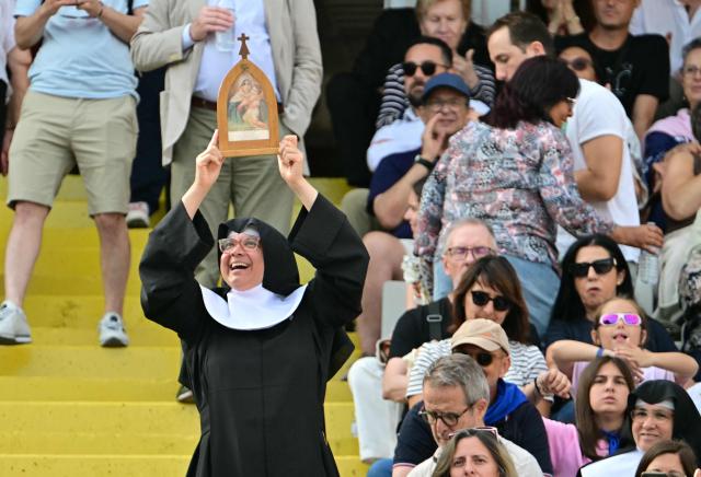 A nun holds a St. Mary image as faithfuls wait prior a prayer vigil at the Lluis Companys Olympic Stadium in Barcelona, on June 9, 2026. Pope Leo XIV is visiting Spain June 6-12 with stops in Madrid, Barcelona, and the Canary Islands, where he will meet with migrants and organisations dedicated to helping them. (Photo by Stefano RELLANDINI / AFP)