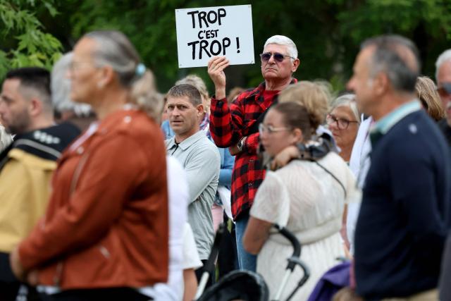 An attendee holds a placard reading "Enough is enough !" as participants march during a rally in memory of late 11-year-old Lyhanna and to demand new child protection laws in the presence of Lyhanna's grand parents and relatives in Saint-Jean d'Angely, south-western France on June 9, 2026, following the disappearance and death of Lyhanna. Outrage has erupted in France after it emerged the main suspect Jerome.B, a 41-year-old father of two, had been repeatedly accused of sexually abusing children but no action was taken to protect others. The 11-year-old's disappearance and death exposed years of unprocessed judicial complaints against her suspected killer. (Photo by ROMAIN PERROCHEAU / AFP)
