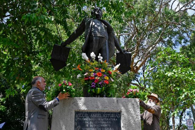 Sandino Asturias (L), grandson of the Nobel Literature laureate Miguel Angel Asturias (1899-1974), and Guatemala's Minister of Culture and Sports Luis Mendez, place floral offerings at his monument during a ceremony marking 52 years since his death in Guatemala City on June 9, 2026. The remains of Guatemalan writer Miguel Angel Asturias will be repatriated from France to Guatemala in mid-October, the government announced. (Photo by Johan ORDONEZ / AFP)