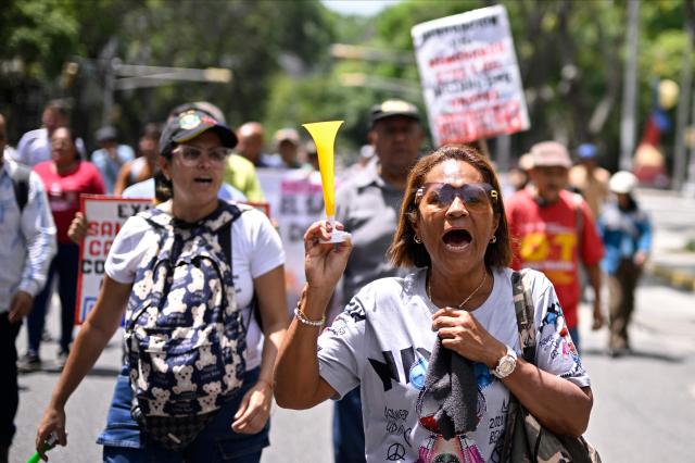 Union workers shout slogans as they take part in a protest demanding better working conditions and presidential elections, outside the Public Prosecutor's Office in Caracas on June 9, 2026. (Photo by Maxwell BRICENO / AFP)