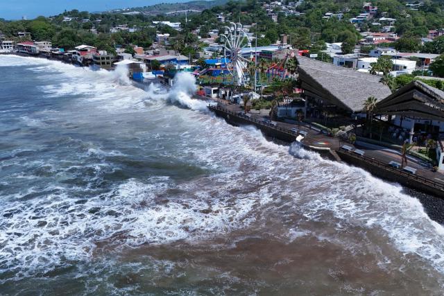 An aerial view shows rough seas near the port of La Libertad ahead of the arrival of Tropical Storm Cristina in La Libertad, El Salvador, on June 9, 2026. The approach of Tropical Storm Cristina on June 9 forced the closure of restaurants and the suspension of fishing activities in the port of La Libertad as part of measures taken by Salvadoran authorities ahead of possible severe weather conditions, according to AFP journalists. (Photo by Rudy QUIROZ / AFP)