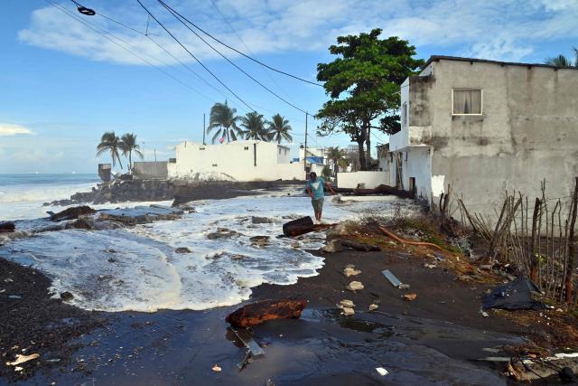 A man walks along a street flooded by waves ahead of the arrival of Tropical Storm Cristina in Itzapa, Guatemala, on June 9, 2026. The countries of Central America remain on alert over the effects of Tropical Storm Cristina, which formed on June 8, 2026 in the Pacific Ocean, civil protection services reported. (Photo by AFP)