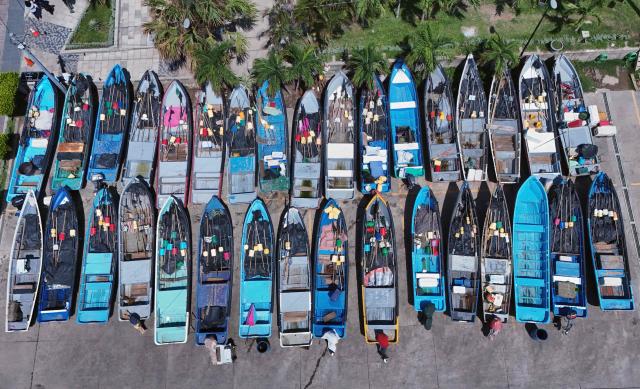 Fishing boats remain moored at the port of La Libertad ahead of the arrival of Tropical Storm Cristina in La Libertad, El Salvador, on June 9, 2026. The approach of Tropical Storm Cristina on June 9 forced the closure of restaurants and the suspension of fishing activities in the port of La Libertad as part of measures taken by Salvadoran authorities ahead of possible severe weather conditions, according to AFP journalists. (Photo by Rudy QUIROZ / AFP)