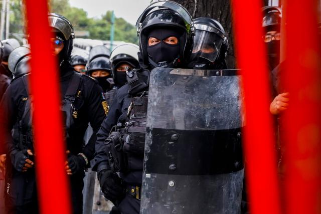 Members of the police block the way to the Ciudad de Mexico Stadium during a protest in Mexico City on June 9, 2026. Thousands of teachers blocked an avenue leading to the Azteca Stadium in Mexico City, 48 hours before the opening ceremony of the 2026 World Cup at that venue. (Photo by Gerardo Magallon / AFP)