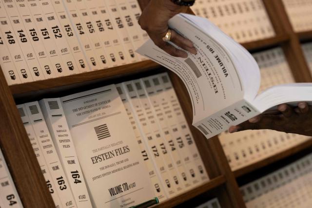 A person looks at a volume at the pop-up exhibit "Donald J. Trump and Jeffrey Epstein Memorial Reading Room" where 3,437 bound volumes of the "Epstein Files" are on display in Washington, DC, on June 9, 2026. (Photo by Brendan Smialowski / AFP)