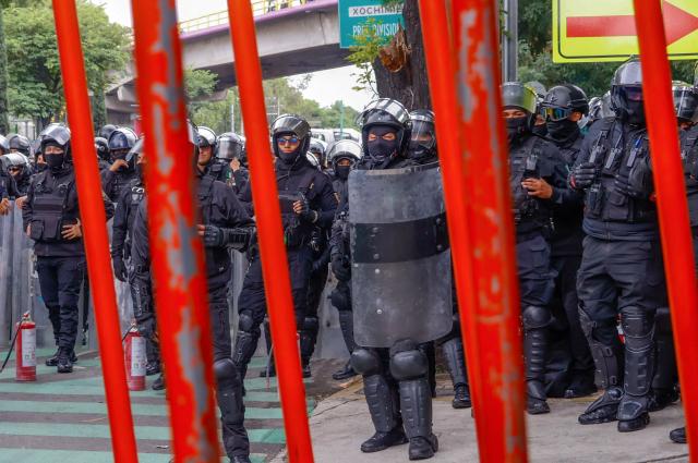 Members of the police block the way to the Ciudad de Mexico Stadium during a protest in Mexico City on June 9, 2026. Thousands of teachers blocked an avenue leading to the Azteca Stadium in Mexico City, 48 hours before the opening ceremony of the 2026 World Cup at that venue. (Photo by Gerardo Magallon / AFP)