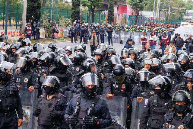 Members of the police block the way to the Ciudad de Mexico Stadium during a protest in Mexico City on June 9, 2026. Thousands of teachers blocked an avenue leading to the Azteca Stadium in Mexico City, 48 hours before the opening ceremony of the 2026 World Cup at that venue. (Photo by Gerardo Magallon / AFP)