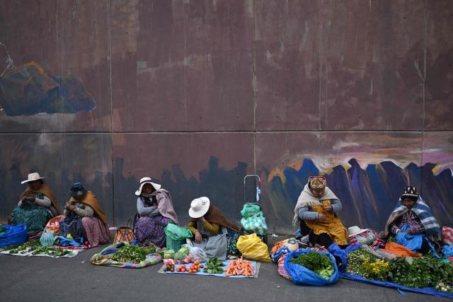 Locals offer their goods at an improvised market along a blocked highway in the Rio Seco area of El Alto, Bolivia, on June 9, 2026. The road, a key transport corridor linking La Paz with Copacabana and the border town of Desaguadero, has been transformed into a bustling marketplace where hundreds of vendors sell food and other goods as anti-government road blockades continue across the country amid growing political tensions and supply shortages. (Photo by Marvin RECINOS / AFP)