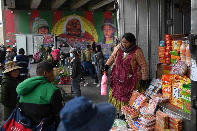 Locals buy goods at an improvised market along a blocked highway in the Rio Seco area of El Alto, Bolivia, on June 9, 2026. The road, a key transport corridor linking La Paz with Copacabana and the border town of Desaguadero, has been transformed into a bustling marketplace where hundreds of vendors sell food and other goods as anti-government road blockades continue across the country amid growing political tensions and supply shortages. (Photo by Marvin RECINOS / AFP)