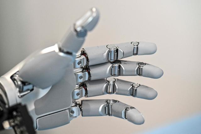The hand of a humanoid robot is seen while being trained to do household tasks at the X Square Robot facilities in Shenzhen, southern China's Guangdong province on May 22, 2026. China's robots have wowed audiences with fluid dancing and set-piece martial arts displays onstage, but their application and performance in real-life settings remains limited. For companies like X Square, the logic of launching an imperfect service lies in data collection for so-called embodied artificial intelligence. (Photo by Hector RETAMAL / AFP) / To go with AFP story China-tech-labour-lifestyle-AI, FOCUS by Emily WANG