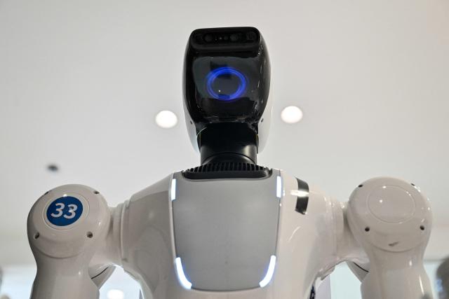 A humanoid robot is seen at the facilities of X Square Robot where robots receive training to do household tasks in Shenzhen, southern China's Guangdong province on May 22, 2026. China's robots have wowed audiences with fluid dancing and set-piece martial arts displays onstage, but their application and performance in real-life settings remains limited. For companies like X Square, the logic of launching an imperfect service lies in data collection for so-called embodied artificial intelligence. (Photo by Hector RETAMAL / AFP) / To go with AFP story China-tech-labour-lifestyle-AI, FOCUS by Emily WANG