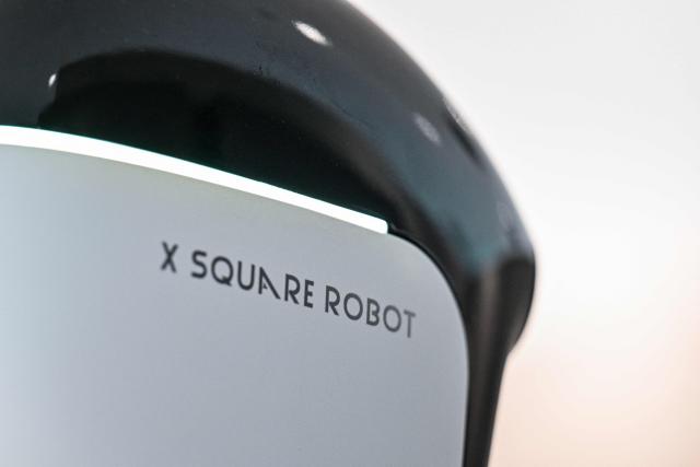 A humanoid robot is seen at the facilities of X Square Robot where robots receive training to do household tasks in Shenzhen, southern China's Guangdong province on May 22, 2026. China's robots have wowed audiences with fluid dancing and set-piece martial arts displays onstage, but their application and performance in real-life settings remains limited. For companies like X Square, the logic of launching an imperfect service lies in data collection for so-called embodied artificial intelligence. (Photo by Hector RETAMAL / AFP) / To go with AFP story China-tech-labour-lifestyle-AI, FOCUS by Emily WANG