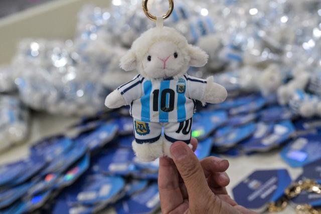 In this photo taken on June 5, 2026, a worker packs merchandise of Lionel Messi of Argentina's national football team, which will participate in the FIFA World Cup 2026, at the All Star Partner factory in Yiwu in eastern China's Zhejiang province. Stuffed "goat" plushies donning Lionel Messi's famous Argentina no. 10 pepper a factory tabletop in eastern China, where sellers are betting on the country's lucrative fan market for a World Cup boost. (Photo by Hector RETAMAL / AFP) / To go with 'CHINA-CONSUMPTION-FBL,FOCUS' by Mary YANG