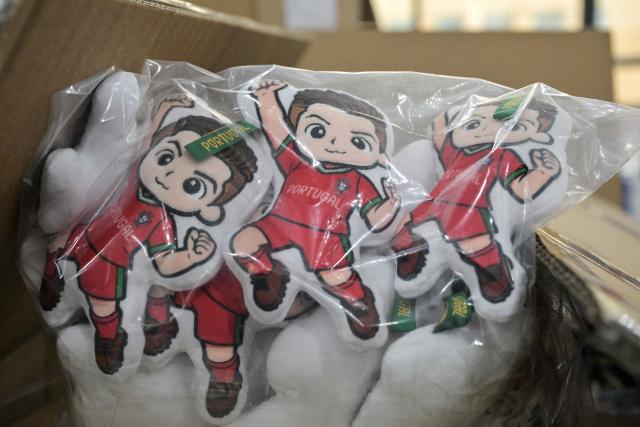 This photo taken on June 5, 2026, shows merchandise for Cristiano Ronaldo of Portugal's national football team, which will participate in the FIFA World Cup 2026, at the All Star Partner factory in Yiwu in eastern China's Zhejiang province. Stuffed "goat" plushies donning Lionel Messi's famous Argentina no. 10 pepper a factory tabletop in eastern China, where sellers are betting on the country's lucrative fan market for a World Cup boost. (Photo by Hector RETAMAL / AFP) / To go with 'CHINA-CONSUMPTION-FBL,FOCUS' by Mary YANG