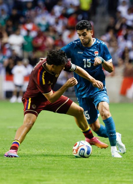 Iraq's defender #15 Ahmed Maknzi and Venezuela's defender #04 Jon Aramburu vie for the ball during the international friendly football match between Iraq and Venezuela at SeatGeek Stadium in Bridgeview, Illinois on June 9, 2026. (Photo by KAMIL KRZACZYNSKI / AFP)