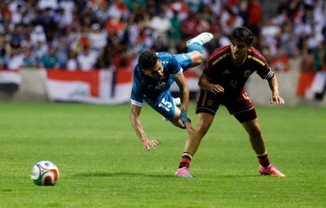 Iraq's defender #15 Ahmed Maknzi and Venezuela's defender #04 Jon Aramburu collide during the international friendly football match between Iraq and Venezuela at SeatGeek Stadium in Bridgeview, Illinois on June 9, 2026. (Photo by KAMIL KRZACZYNSKI / AFP)