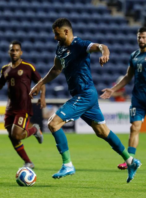 Iraq's forward #18 Aymen Hussein runs with the ball during the international friendly football match between Iraq and Venezuela at SeatGeek Stadium in Bridgeview, Illinois on June 9, 2026. (Photo by KAMIL KRZACZYNSKI / AFP)
