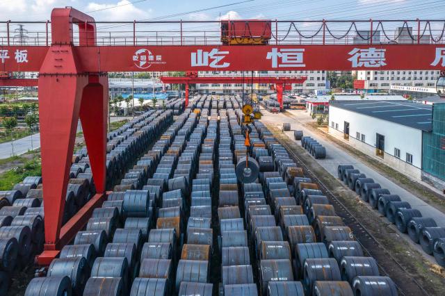 Workers hoist a roll of steel at a steel wholesale market in Shenyang, in China’s northeast Liaoning province, on June 10, 2026. (Photo by CN-STR / AFP) / China OUT