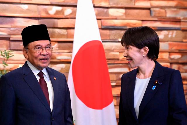 Japan's Prime Minister Sanae Takaichi (R) and Malaysia's Prime Minister Anwar Ibrahim (L) pose for photographs ahead of their bilateral meeting at the Prime Minister’s Office in Tokyo on June 10, 2026. (Photo by David Mareuil / POOL / AFP)