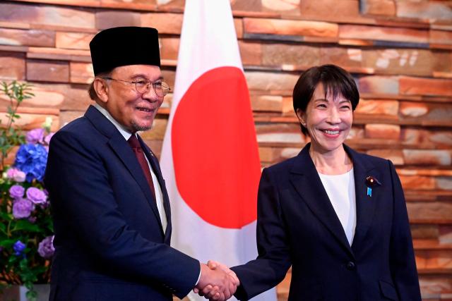 Japan's Prime Minister Sanae Takaichi (R) and Malaysia's Prime Minister Anwar Ibrahim (L) pose for photographs ahead of their bilateral meeting at the Prime Minister’s Office in Tokyo on June 10, 2026. (Photo by David Mareuil / POOL / AFP)