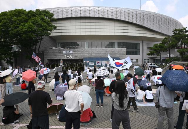 South Korean protesters wave the national flags outside a vote-counting centre in Seoul on June 10, 2026, to call for a rerun of the local elections due to a shortage of ballot papers. South Korean authorities agreed on June 9 to launch an investigation into ballot paper shortages at recent local elections, local media reported, following widespread protests. (Photo by Jung Yeon-je / AFP)