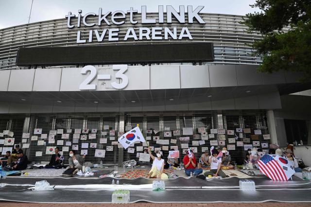 South Korean protesters wave the national flags outside a vote-counting centre in Seoul on June 10, 2026, to call for a rerun of the local elections due to a shortage of ballot papers. South Korean authorities agreed on June 9 to launch an investigation into ballot paper shortages at recent local elections, local media reported, following widespread protests. (Photo by Jung Yeon-je / AFP)
