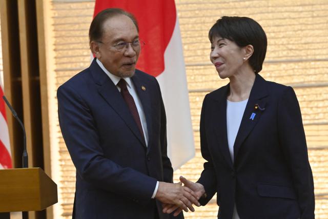 Japan's Prime Minister Sanae Takaichi (R) and Malaysia's Prime Minister Anwar Ibrahim (L) shake hands at the end a joint press announcement following their bilateral meeting at the Prime Minister’s Office in Tokyo on June 10, 2026. (Photo by David Mareuil / POOL / AFP)