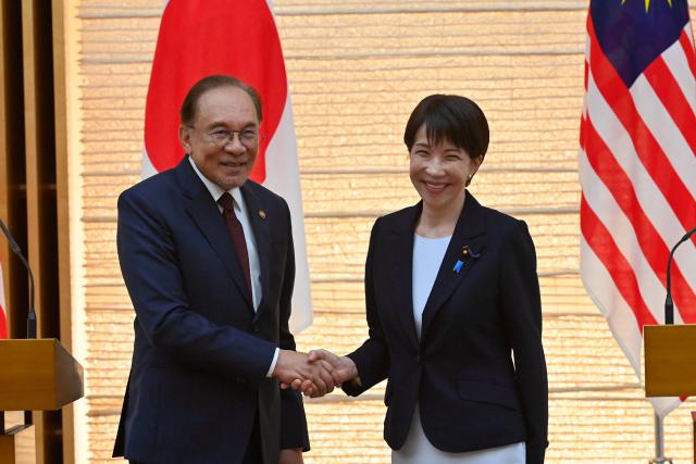 Japan's Prime Minister Sanae Takaichi (R) and Malaysia's Prime Minister Anwar Ibrahim (L) shake hands at the end a joint press announcement following their bilateral meeting at the Prime Minister’s Office in Tokyo on June 10, 2026. (Photo by David Mareuil / POOL / AFP)