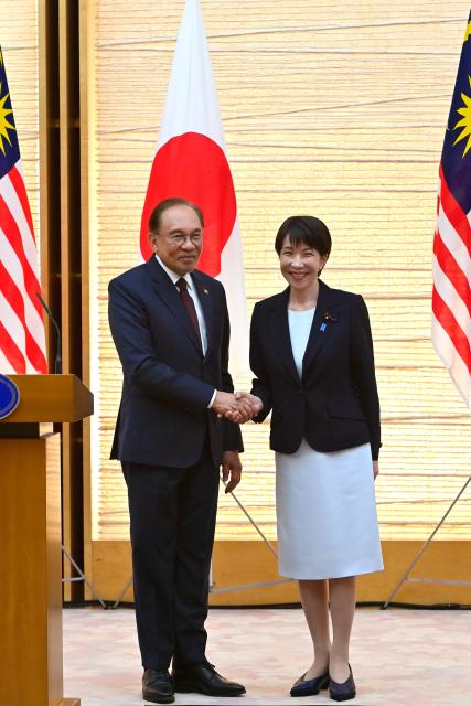 Japan's Prime Minister Sanae Takaichi (R) and Malaysia's Prime Minister Anwar Ibrahim (L) shake hands at the end a joint press announcement following their bilateral meeting at the Prime Minister’s Office in Tokyo on June 10, 2026. (Photo by David Mareuil / POOL / AFP)