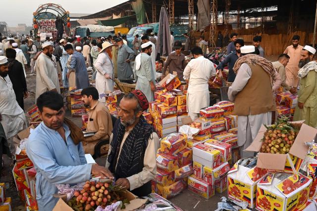Fruit traders wait for customers at a wholesale market in Peshawar on June 10, 2026. (Photo by Abdul MAJEED / AFP)