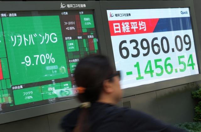 Electronic bulletin boards display a 9.70 percent drop in SoftBank Group's stock price (top L) and the Nikkei 225 average on the Tokyo Stock Exchange (R) along a street in Tokyo on June 10, 2026. (Photo by Kazuhiro NOGI / STR / AFP)
