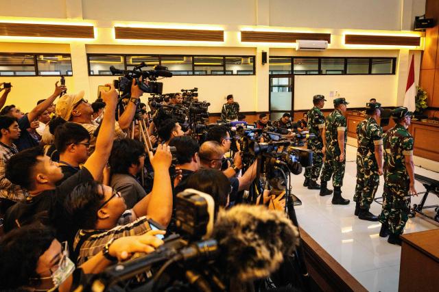 Members of the media record as four Indonesian military personnel accused of throwing acid at a human rights activist attend a verdict hearing at a military court in Jakarta on June 10, 2026. A military court in Indonesia on June 10 sentenced four soldiers to up to three years in prison for an acid attack on an activist critical of perceived militarisation of the government. (Photo by Yasuyoshi Chiba / AFP)