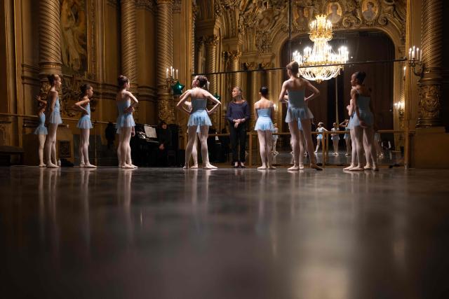 Female students from the 6th division of the Paris Opera Dance School warm up before a performance in the Foyer de la Danse at the Opera Garnier in Paris on December 15, 2024. It is a tradition passed down orally, from one generation of young dancers to the next: at the Paris Opera Ballet School, students are taught the art of French classical ballet, a three-century-old artistic heritage that is attracting more and more foreign dancers. (Photo by JOEL SAGET / AFP)