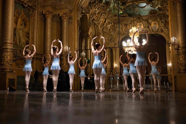 Female students from the 6th division of the Paris Opera Dance School warm up before a performance in the Foyer de la Danse at the Opera Garnier in Paris on December 15, 2024. It is a tradition passed down orally, from one generation of young dancers to the next: at the Paris Opera Ballet School, students are taught the art of French classical ballet, a three-century-old artistic heritage that is attracting more and more foreign dancers. (Photo by JOEL SAGET / AFP)