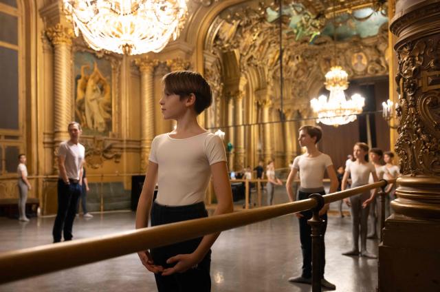 Boys from the 5th division of the Paris Opera Dance School warm up before a performance in the Foyer de la Danse at the Opera Garnier in Paris on December 15, 2024. It is a tradition passed down orally, from one generation of young dancers to the next: at the Paris Opera Ballet School, students are taught the art of French classical ballet, a three-century-old artistic heritage that is attracting more and more foreign dancers. (Photo by JOEL SAGET / AFP)