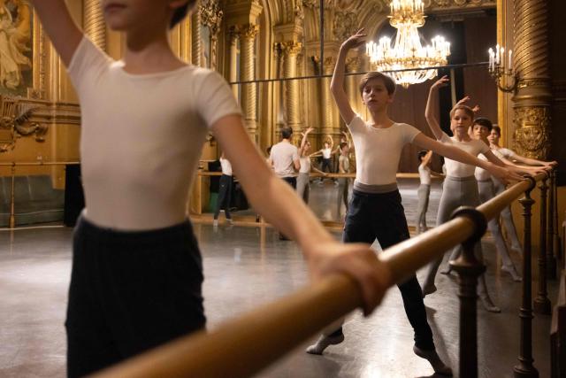 Boys from the 5th division of the Paris Opera Dance School warm up before a performance in the Foyer de la Danse at the Opera Garnier in Paris on December 15, 2024. It is a tradition passed down orally, from one generation of young dancers to the next: at the Paris Opera Ballet School, students are taught the art of French classical ballet, a three-century-old artistic heritage that is attracting more and more foreign dancers. (Photo by JOEL SAGET / AFP)